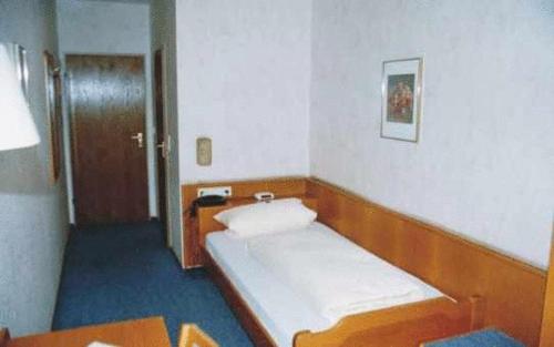 Kleines Zimmer mit einem Bett und einem Tisch in der Unterkunft Hotel Ludwigstal in Schriesheim