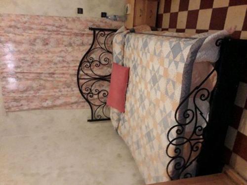 ein Bett mit einem Eisengeländer neben einer Wand in der Unterkunft dar stefano in Essaouira