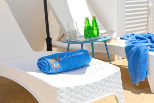 a white chair with a table with bottles on it at Alasia Villas in Paralimni