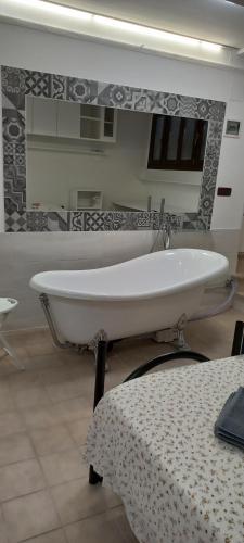 a white bath tub in a bathroom with a table at Le Due Palme House in Torre San Giovanni Ugento