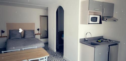 a small room with a bed and a sink at Studio aux portes d' Amiens in Cagny