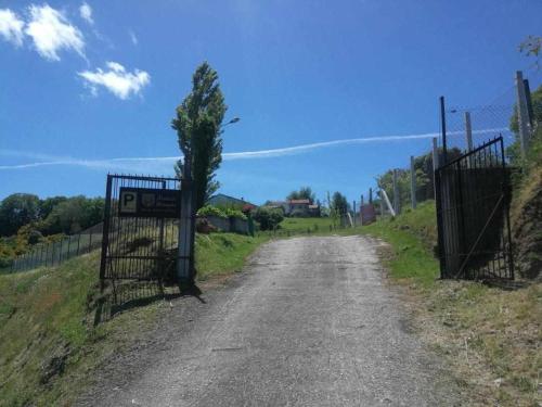 a dirt road with a gate and a tree at Alcázar Milmanda in Milmanda