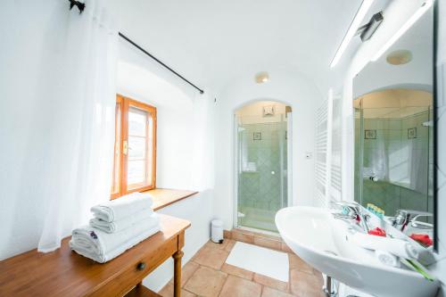 a white bathroom with a sink and a shower at Smile Apartments mit Donaublick in Dürnstein