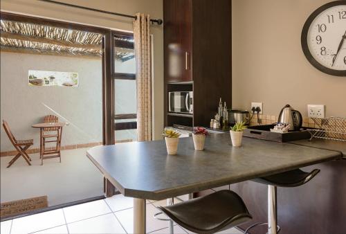 a kitchen with a table and a clock on the wall at Kakamas Hotel in Kakamas