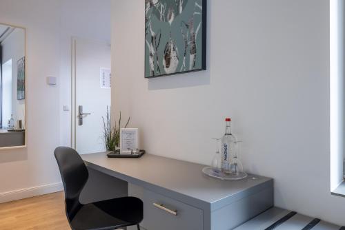 a desk with a black chair in a room at Hotel KO15 in Lübeck