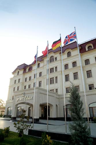 a building with flags in front of it at Termez Palace Hotel & Spa in Termiz