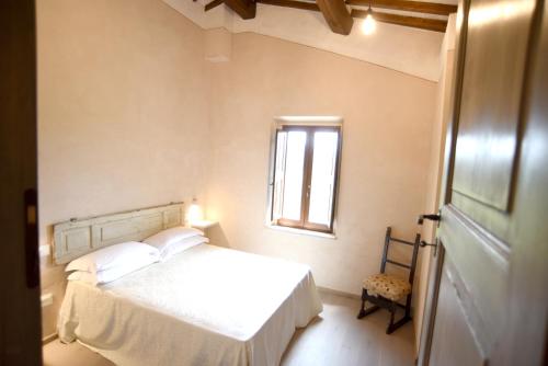 a bedroom with a white bed and a window at Borgo Colognola - Dimora Storica in Cenerente