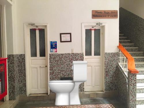 a bathroom with a toilet in a building with stairs at Hotel de los baños in Pachuca de Soto