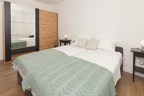 - une chambre avec un grand lit blanc et une salle de bains dans l'établissement Villa Abelia, à Pirovac