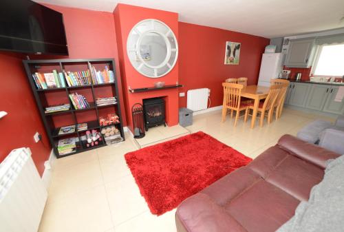 a living room with a couch and a red wall at Notting Hill West in the heart of Westport Town in Westport