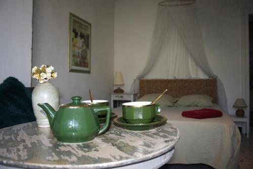 a room with a table with two tea pots and a bed at SAUVEURS DE REVES 2 suites indépendantes et un F2 privé dans un hôtel particulier in Sauve