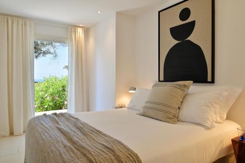 a bedroom with a large white bed with a window at Résidence Terra Marina in Bonifacio