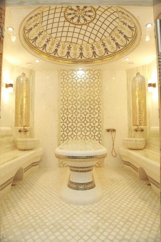 a bathroom with a tub and a toilet in a room at Termez Palace Hotel & Spa in Termiz