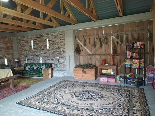 a living room with a large rug on the floor at Dolistówka Apartamenty, pole namiotowe, balia z jacuzzi, ogród warzywny dla gości, plac zabaw dla dzieci in Goniadz