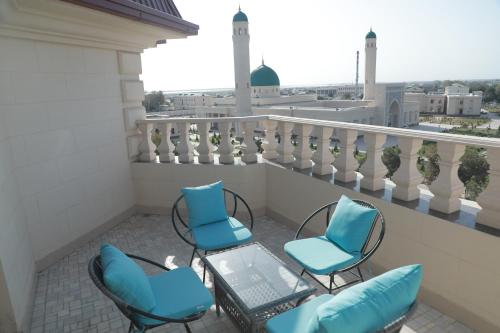 a balcony with chairs and a table with a laptop at Termez Palace Hotel & Spa in Termiz