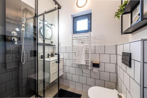 La salle de bains est pourvue d'une douche en verre et de toilettes. dans l'établissement Villa Uno Balaton, à Balatonakarattya