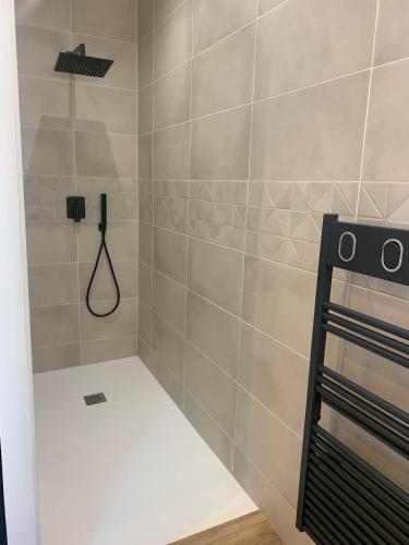 a bathroom with a shower with a phone on the wall at Chambre avec entrée indépendante in Lamastre