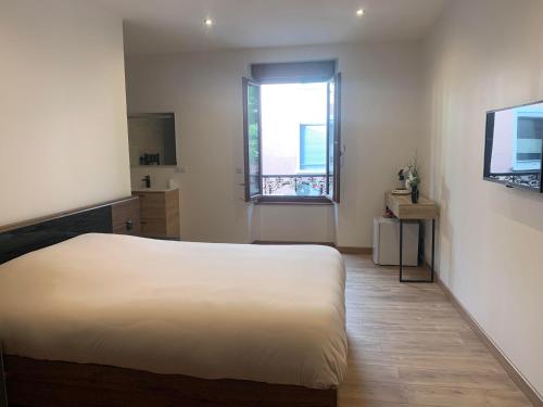 a bedroom with a white bed and a window at Chambre avec entrée indépendante in Lamastre