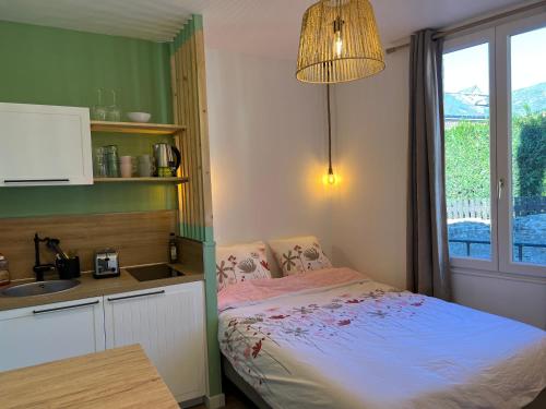 une chambre avec un lit, un lavabo et une fenêtre dans l'établissement Studio La Capucine centre ville Honfleur, à Honfleur