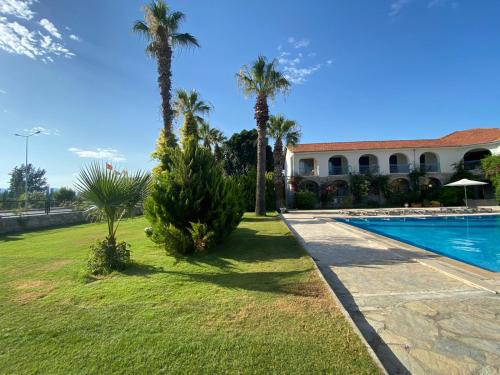 a house with palm trees and a swimming pool at BURÇ HOTEL in Dalaman