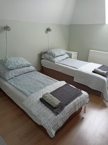 two beds sitting in a room with at Mókus Apartman in Balatongyörök