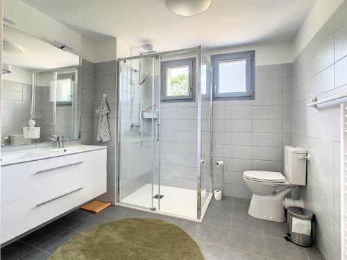 a bathroom with a shower and a toilet and a sink at Superbe appartement entièrement rénové au pied des montagnes avec parking inclus in Bagnères-de-Bigorre