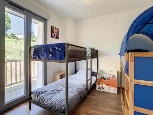 a bedroom with two bunk beds and a balcony at Superbe appartement entièrement rénové au pied des montagnes avec parking inclus in Bagnères-de-Bigorre