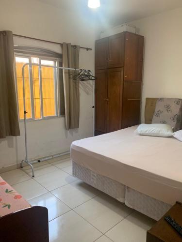 Un dormitorio con una cama grande y una cómoda. en Casa de praia aconchegante próxima ao centro, en Mongaguá