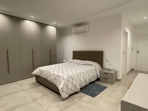 Balzan Luxury Living في Ħal Balzan: غرفة نوم بسرير كبير وموقف ليلي