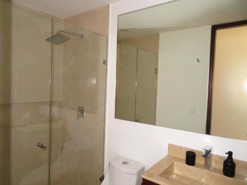 Un baño con ducha, lavabo y espejo. en Elegant apartment well located in the hotel zone of Cancun, en Cancún