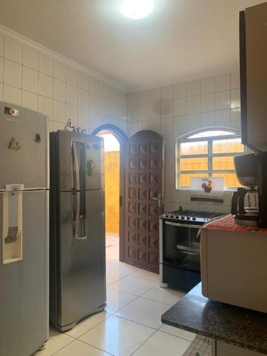 una cocina con refrigerador y estufa en Casa de praia aconchegante próxima ao centro, en Mongaguá