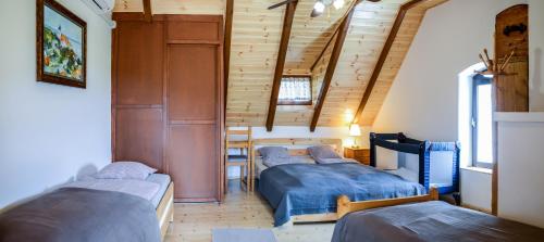 three beds in a room with wooden walls at Máli Pince in Aszófő