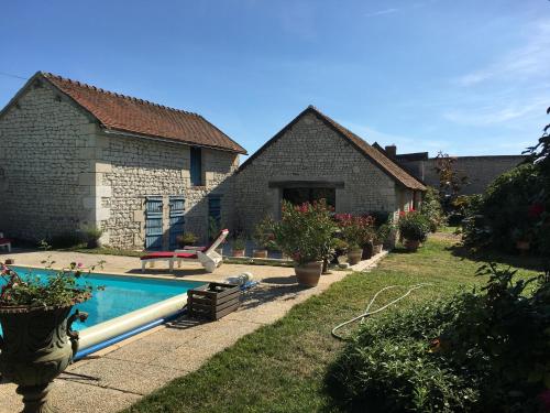 une maison avec une piscine dans une cour dans l'établissement VALINIERE VILLAGE maison détente TENNIS ET PISCINE, à Champigny-sur-Veude