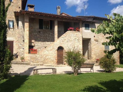 a stone building with a bench in front of it at Fattoria di Rigone in Coltavolino