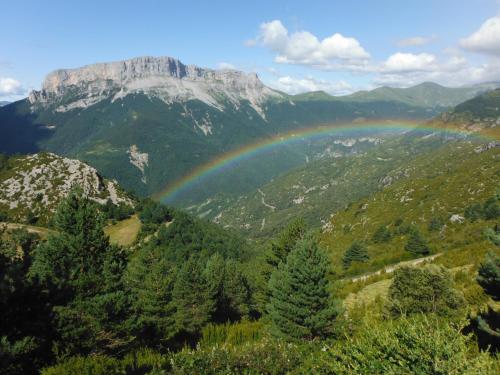 a rainbow over a valley with a mountain at Apartamentos Casa Borja in Salinas de Bielsa