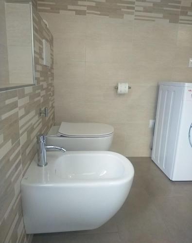 a bathroom with a white toilet and a sink at Casa BRUMANA in Tirano