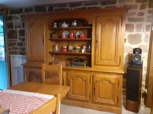 une cuisine avec des placards en bois et une table dans l'établissement L'EveStephTom, à Chassiers