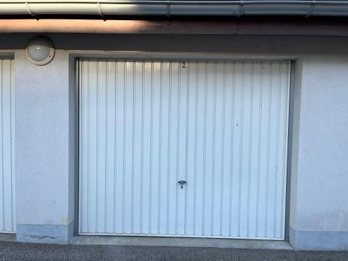 two large white garage doors on a building at Entre Lac d'Annecy et montagnes, golf et parapente à pieds in Talloires