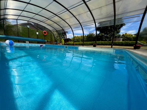 a large swimming pool with a canopy over it at Cypress Log Cabins Accommodation in Godshill