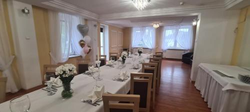 a dining room with tables and chairs with flowers on them at SELMENT RESORT Mazury in Ełk