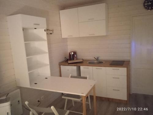 eine kleine Küche mit Tisch und Spüle in der Unterkunft Studio au fil de l'eau in Saulzoir