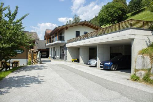 ein Haus mit zwei Autos in einer Garage in der Unterkunft Ferienwohnungen Zinzlerbauer in Uttendorf
