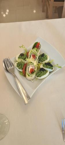a plate of salad on a table with a fork at SELMENT RESORT Mazury in Ełk