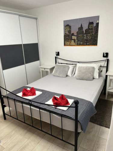 a bedroom with a bed with red pillows on it at Apartments Logos in Trogir