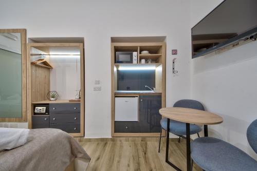 a bedroom with a bed and a table and chairs at Tritoni Mini Studios - Valletta in Il-Furjana
