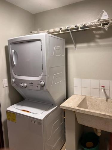 a kitchen with a tv on top of a refrigerator at madrigal 1-3br with parking in Santiago de los Caballeros