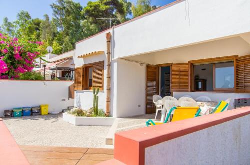 een villa met een patio en een huis bij Melograno in San Vito lo Capo