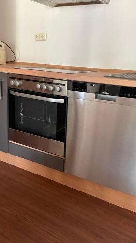 a kitchen with a stainless steel oven and a counter at OASE im grünen Hinterhof, EG, Ruhe, Terrasse, Carport, free PayTV, Kaffee&Tee, Fahrräder in Duisburg