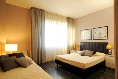 a hotel room with two beds and a window at Residence Oliveto in Ceriale