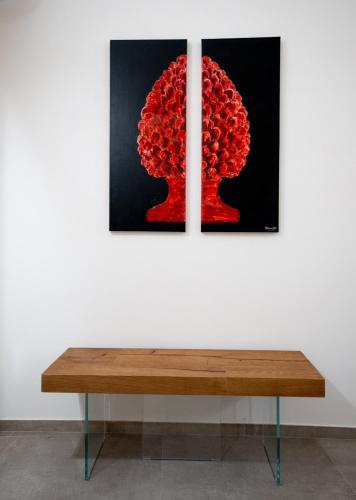 a bench in front of a wall with two paintings at Setteminne Resort Design in Favignana